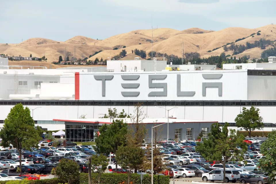 Tesla factory in Fremont, California with dry hills in background.